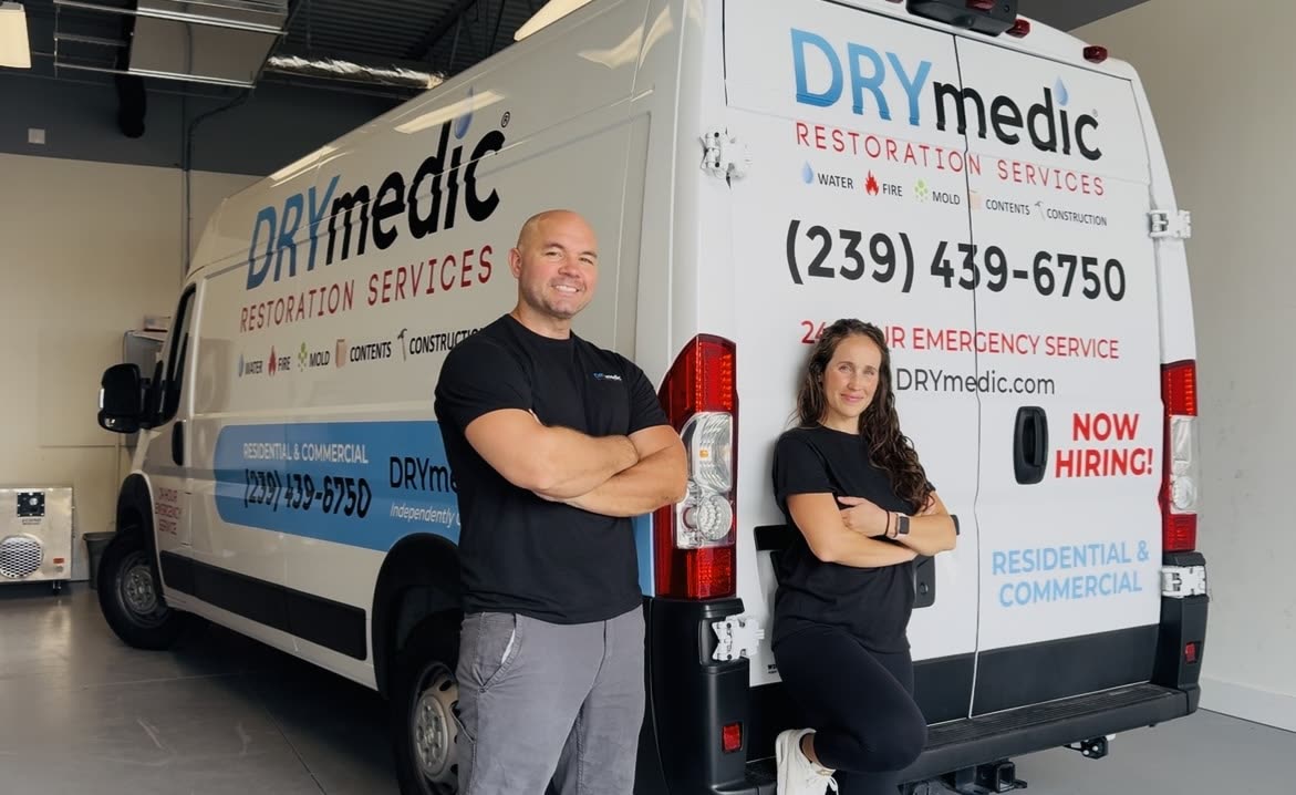Nate and Kate, owners of DRYmedic Restoration of Cape Coral, standing with their DRYmedic service van